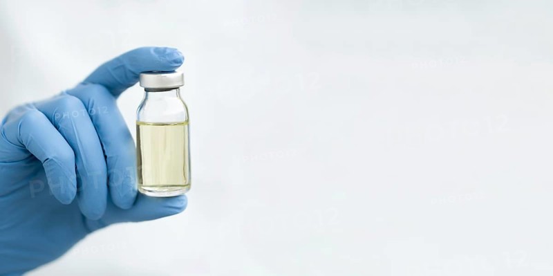 Front view doctor hand holding vaccine with copy space