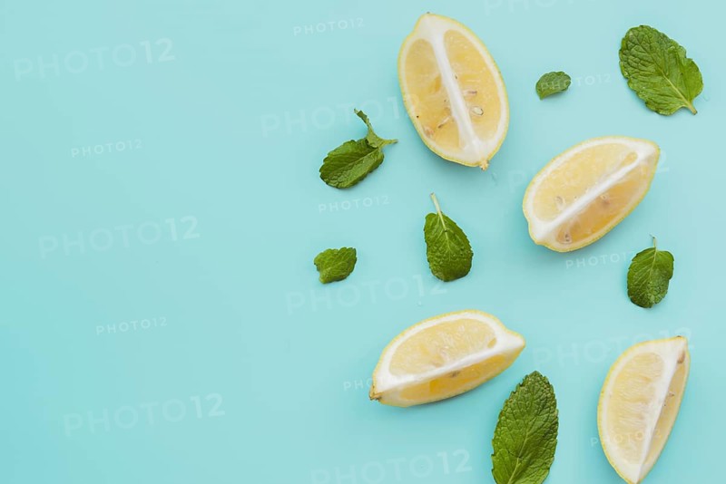Lemon wedges mint leaves background