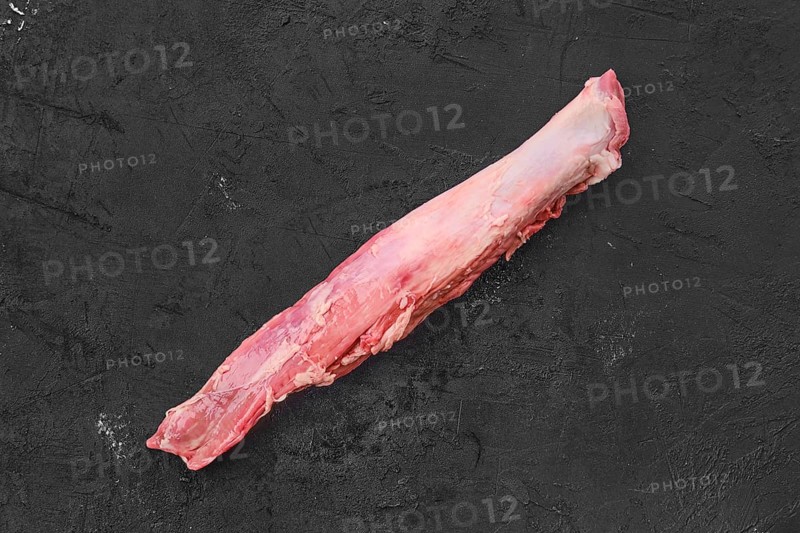 Top view of raw fresh pork fillet on black background