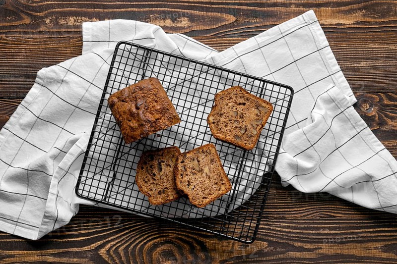 Overhead view of biscuit cake with walnut on baking grid