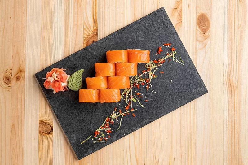Set of rolls with wasabi and pickled ginger on stone serving board