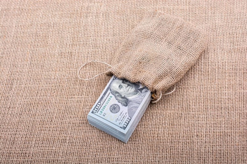Banknote bundle of US dollarin a sack on a canvas