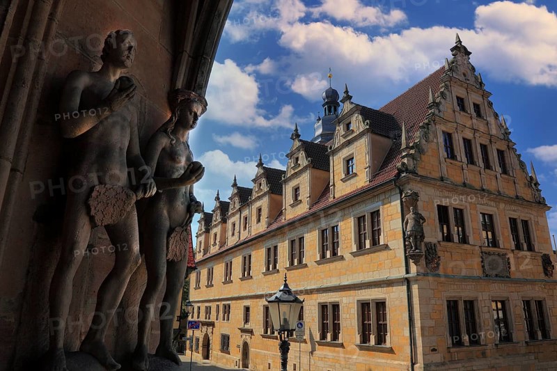 The figures of Adam and Eve on the main portal of the church of St. Moritz and the building of the Casimirianum grammar school