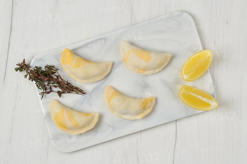 Top view of semifinished frozen salmon dumplings on serving board