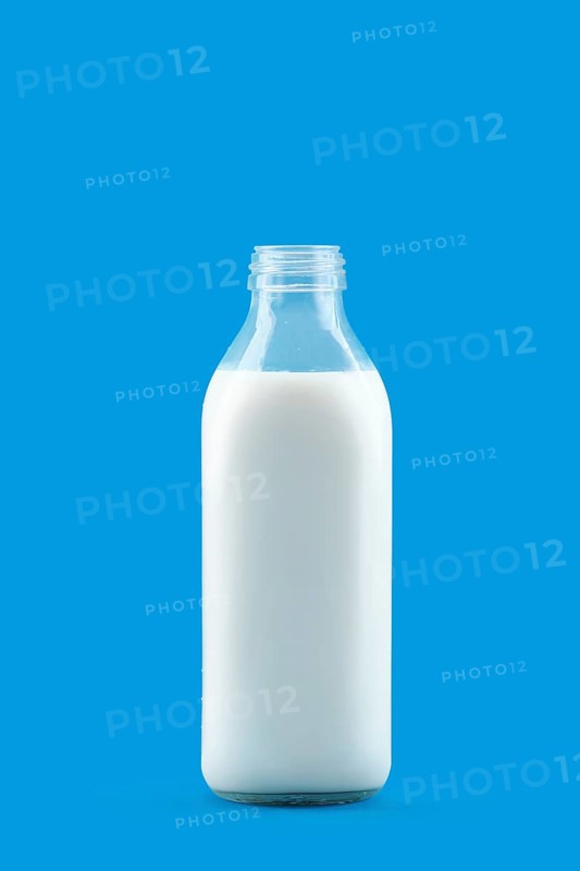 Open bottle of milk isolated on blue background