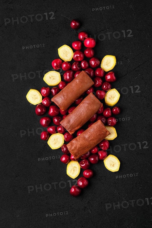 Overhead composition with thin chocolate pancakes stuffed with curd