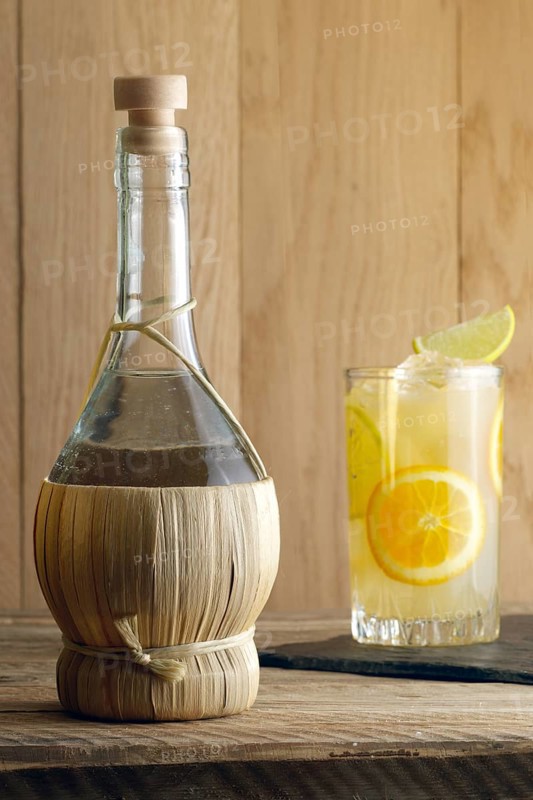 Bottle of homemade Vodka and glass witn orange juice cocktail