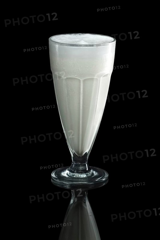 Glass of cold milk cocktail isolated on black