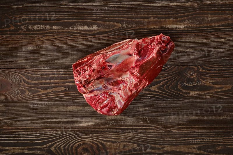 Raw fresh beef shank cross-cut on wooden background