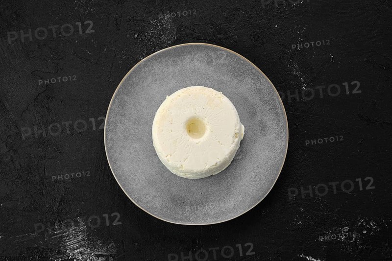 Top view of pressed cottage curd cheese on ceramic plate