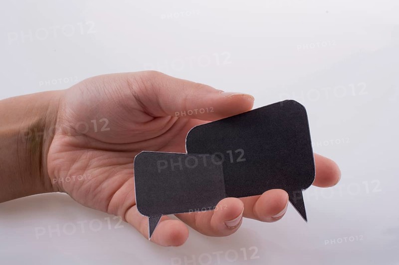 Hand holding dialogue boxes on a white background