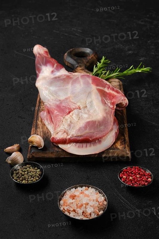 Raw fresh lamb shoulder on wooden cutting board