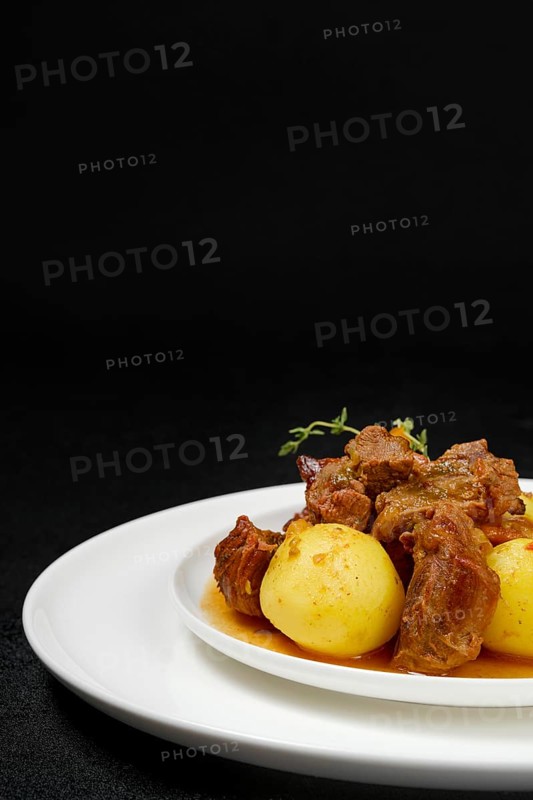 Closeup view of lamb stew with potato on a plate