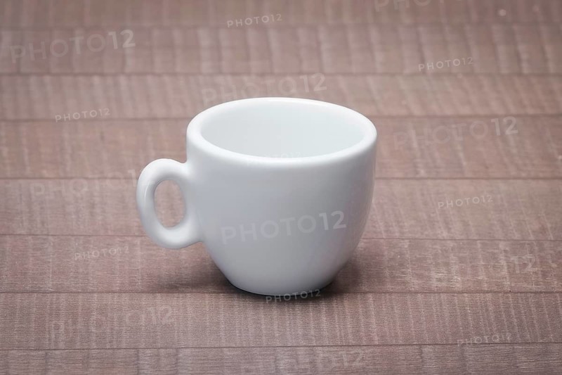 Clean and empty ceramic cup for espresso without saucer on wooden table