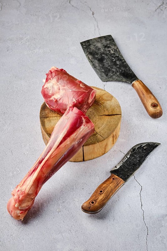 Overhead view of raw fresh deer shank with spice and herb over concrete background