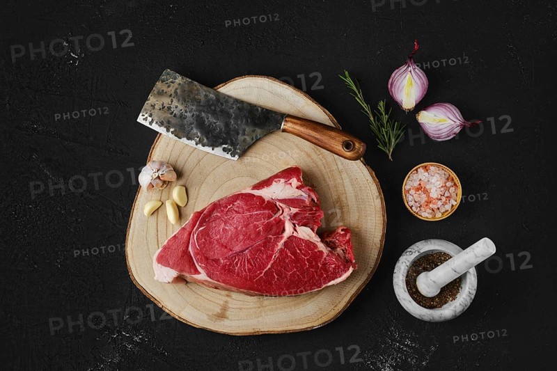 Overhead view of raw top round roast beef steak on wooden cutting board