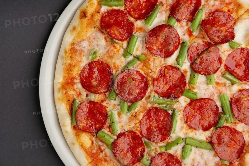 Top view of part of pizza pepperoni on black table