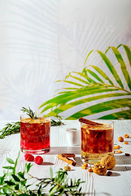 Refreshing espresso and tonic summer drinks on white table under hard sulight