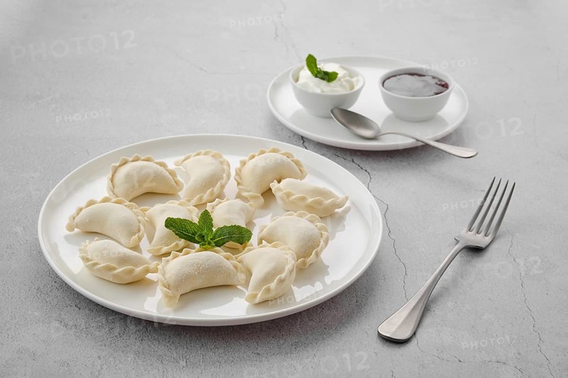 Frozen semifinished vareniki stuffed with cherry on grey background