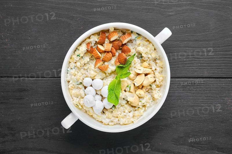 Overhead view of bulgur porridge with almond nuts and hazelnuts and cranberries in sugar pouder breading