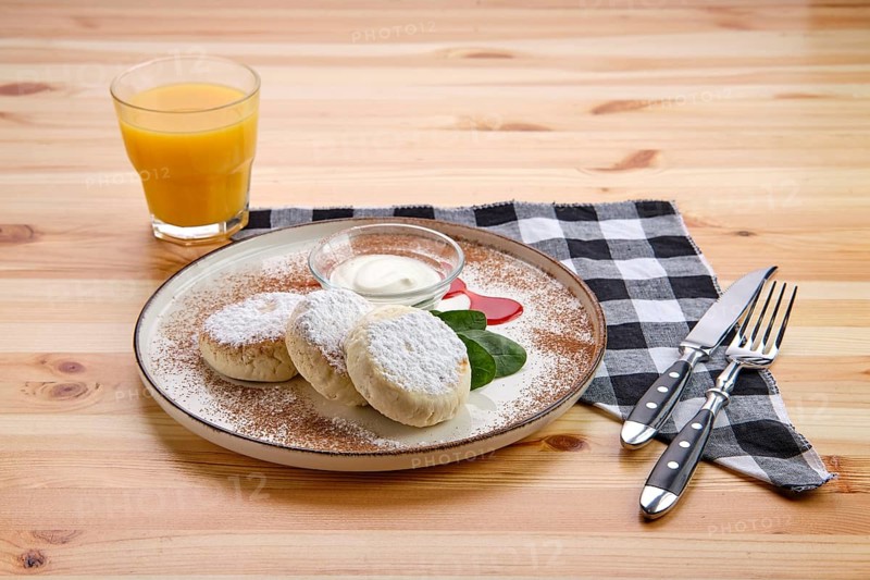 Traditional breakfast with cottage cheese pancake with sour cream