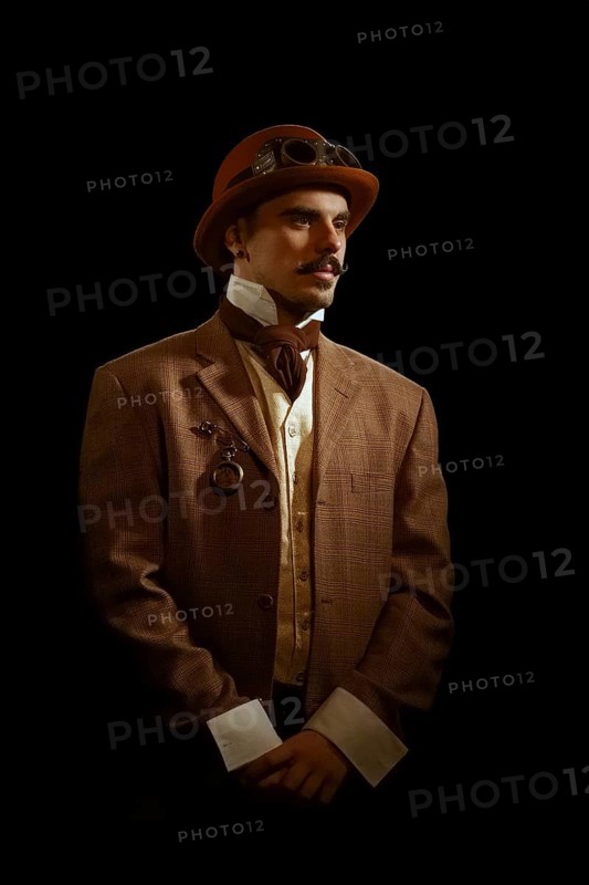 Portrait of steampunk man in hat and glasses. Photo contains strong noise due to low light and high ISO