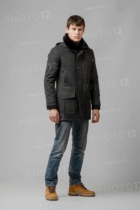 Full length portrait of handsome man in warm winter coat posing in studio