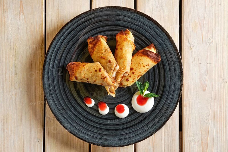 Overhead view of thin pancakes with fruit stuffing