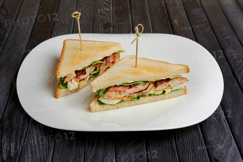 Plate with club sandwich on wooden table