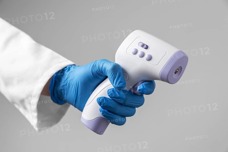 Doctor with gloves holding thermometer