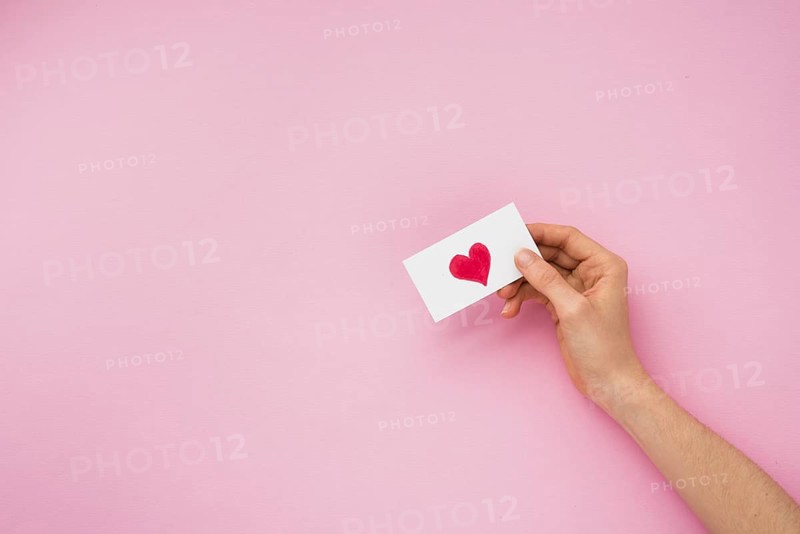 Person hand holding paper with heart picture