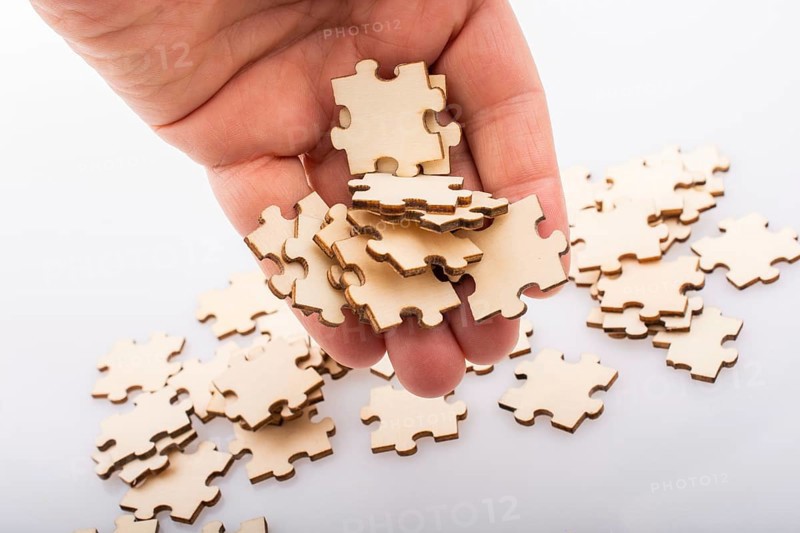 Hand holding piece of jigsaw puzzle as problem solution concept