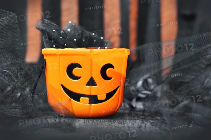 Orange trick or treat Halloween basket with carved pumpkin face