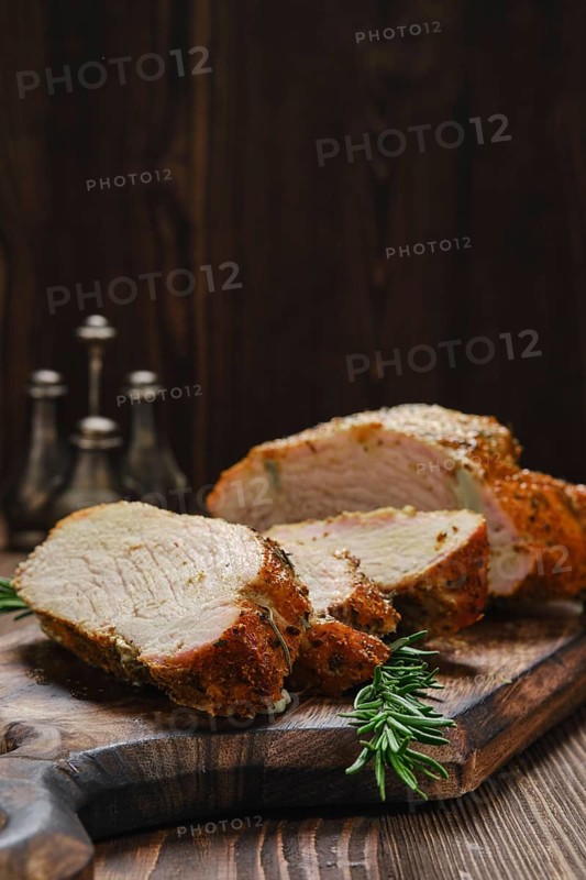 Closeup view of pork collar joint baked in oven on wooden cutting board