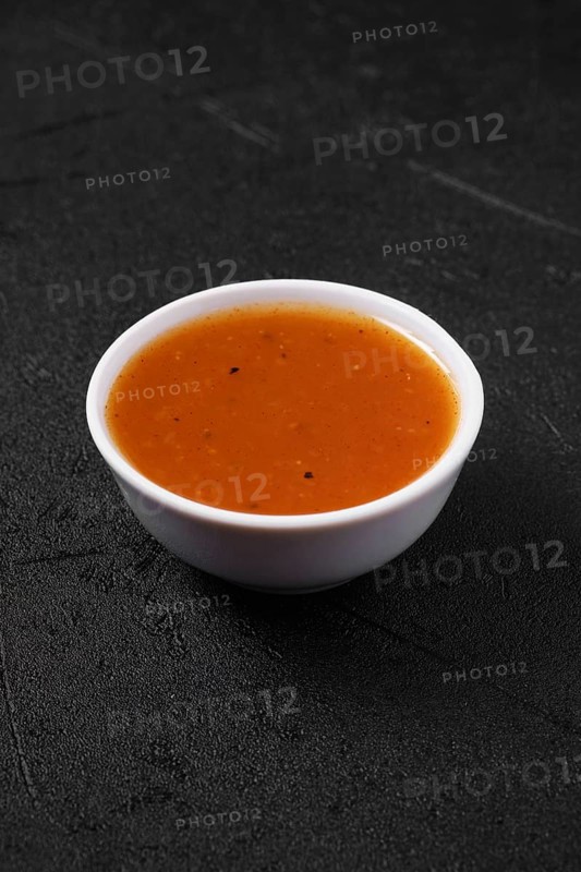 Small bowl with spicy orange sauce for poultry