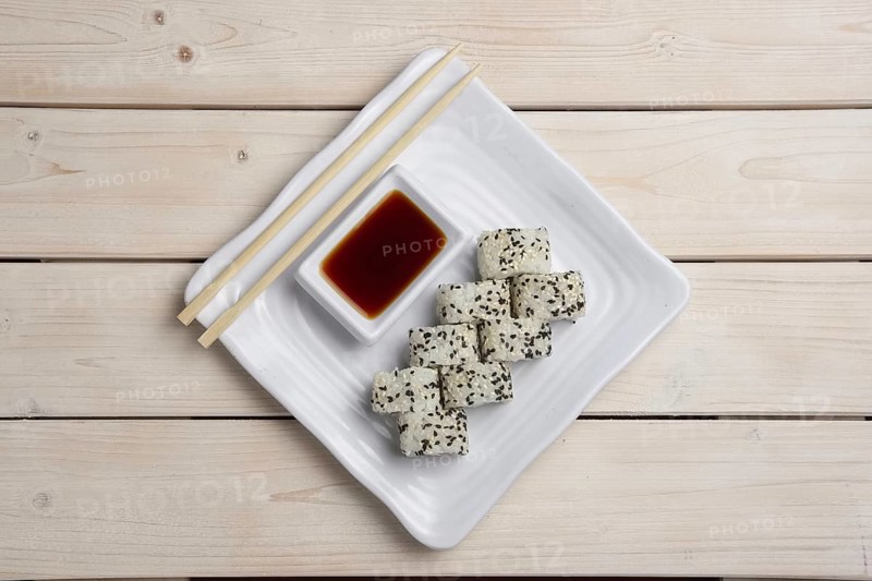 Top view of plate with salmon rolls with hashi and siy sauce