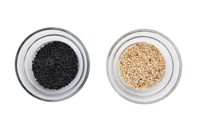 Top view of sesame seeds in a little bowls isolated on white background