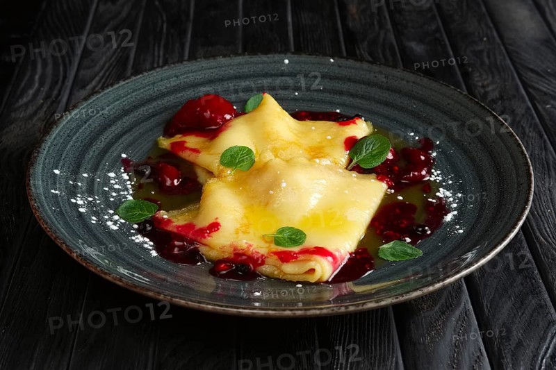 Pancakes with cherry jam decorated with mint leaves