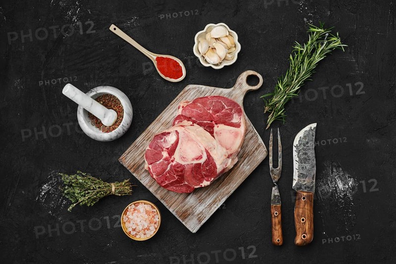 Overhead view of raw beef ossobuco steak with spices