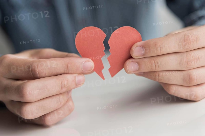 Close up hands holding broken heart