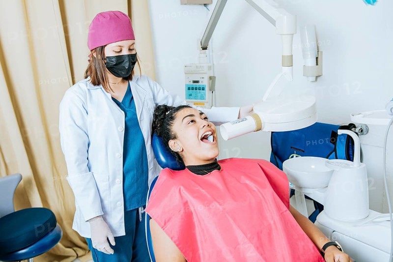 Dentist performing intraoral dental x-ray on a patient