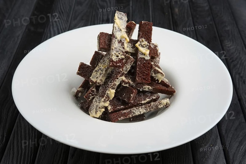 Fried brown bread sticks with melted cheese on a plate