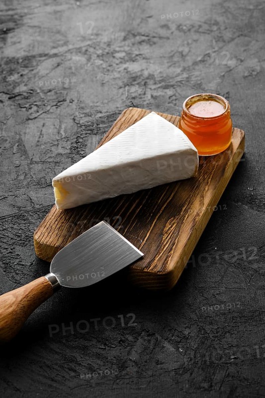 Piece of soft brie or camembert cheese on cutting board