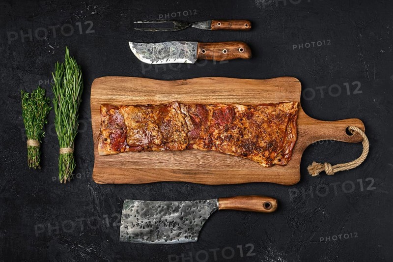 Top view of grilled lamb breast ribs on wooden cutting board