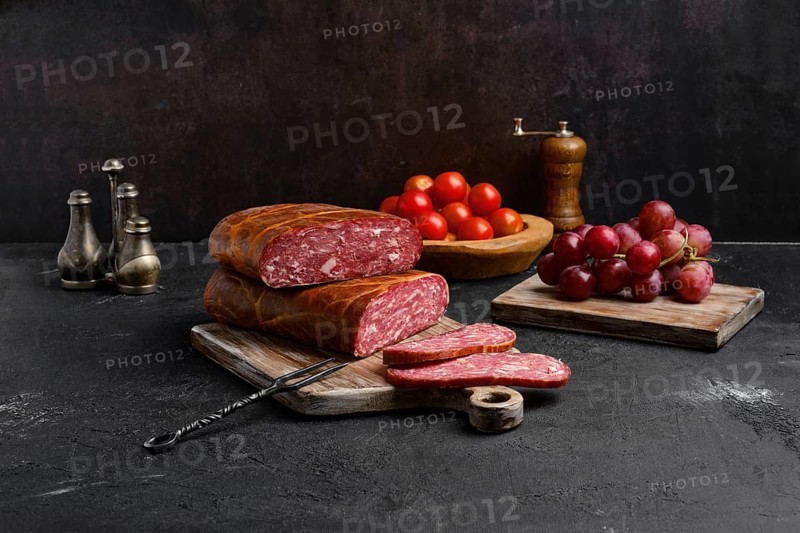 Homemade smoked beef sausage in organic casing on wooden cutting board