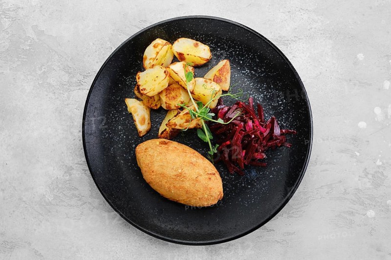 Kiev or pozharskaya cutlet served with fried potato and beet on a plate
