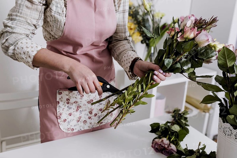 Crop florist preparing flowers