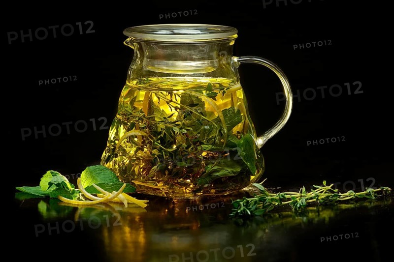 Pot with fruit tea on black background.