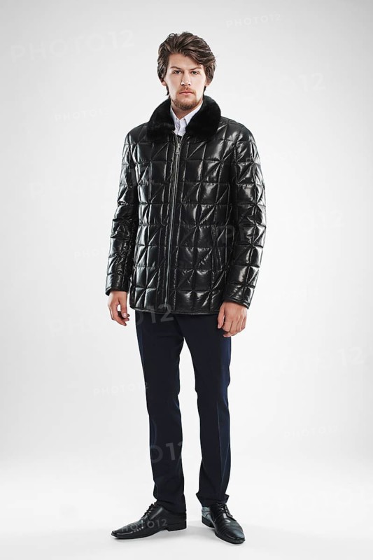 Brutal handsome unshaven man with beard and moustache in waterproof coat with fur collar