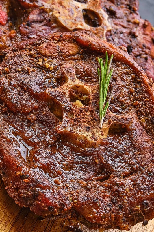 Macro photo of grilled lamb neck on wooden cutting board